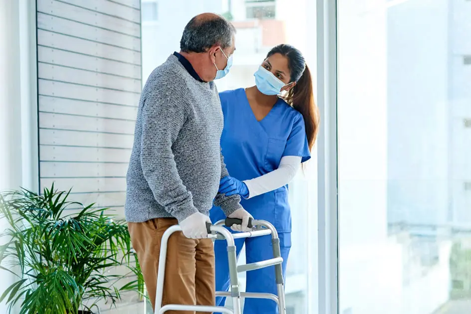 A nurse helping a patient with a walking assist