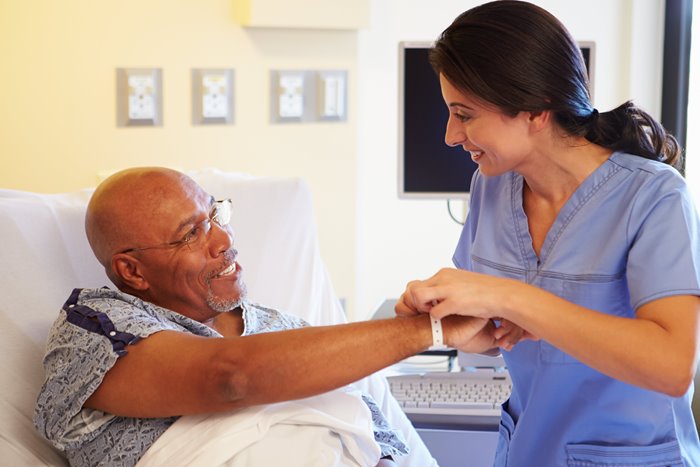 Nurse helping a patient in hospital bed