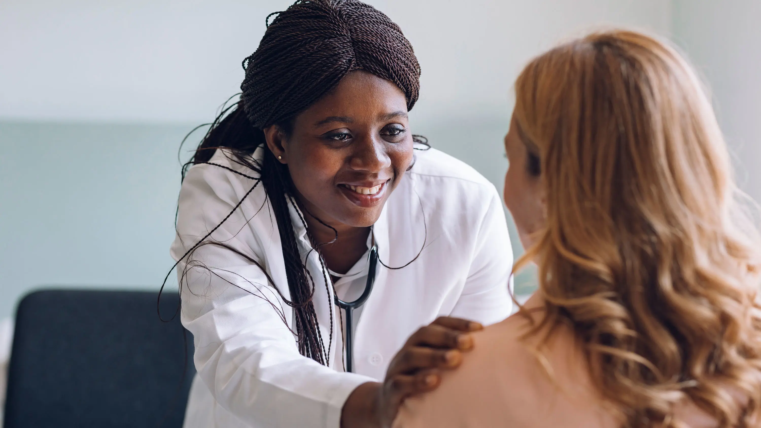A doctor talking to a patient with a hand on their shoulder