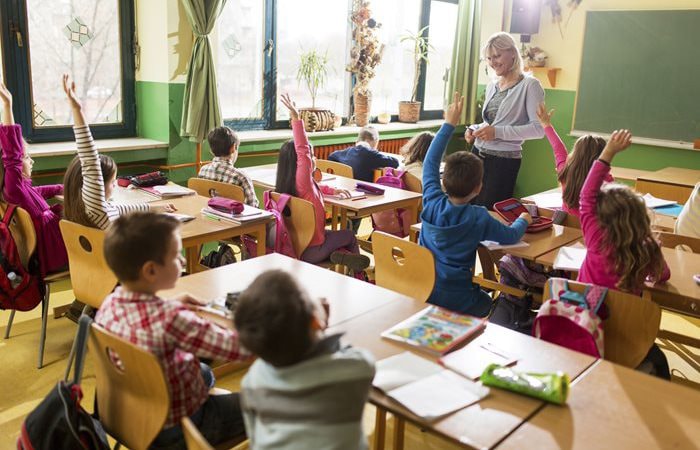 Sunny classroom with teacher standing in front of seated students