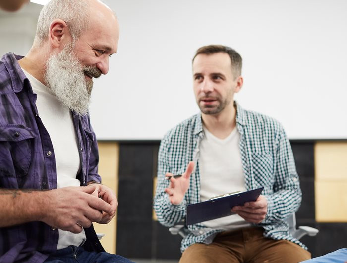Two men sitting and discussing paperwork