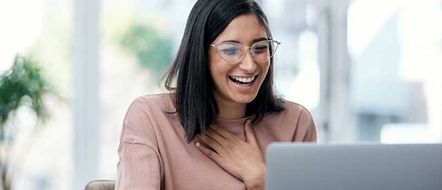 woman smiling looking at her computer