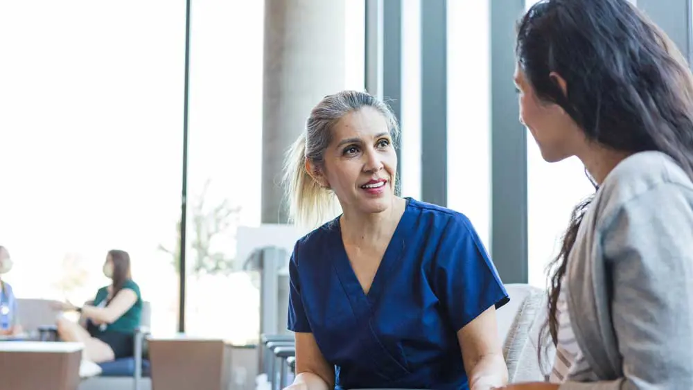 Nurse talking to a patient whilst sitting
