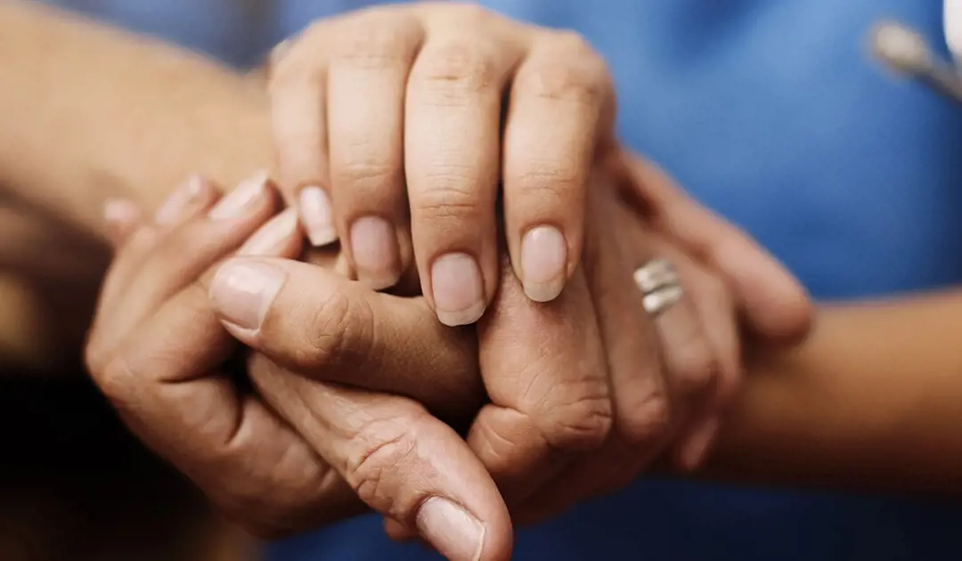 Customer service hand holding older person's hand