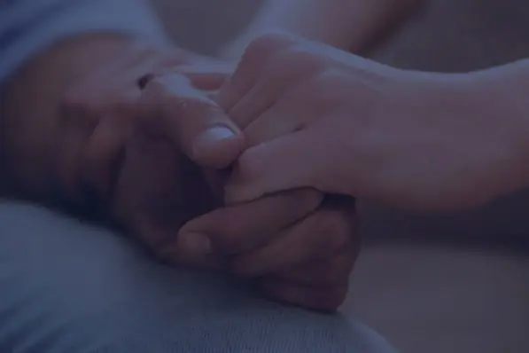 Two hands holding each other in a moment of comfort