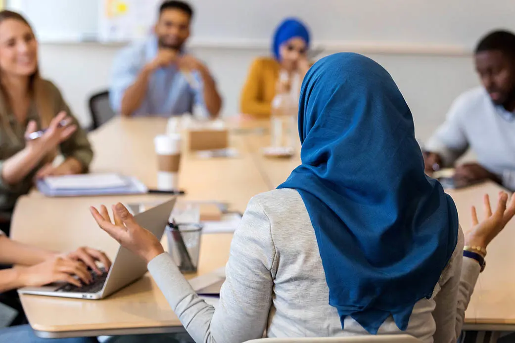 People having a conversation during a meeting.