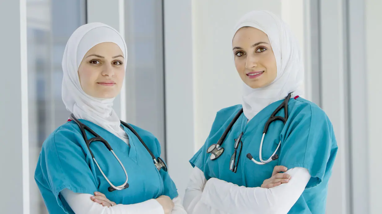 Three medical professionals walking and talking.