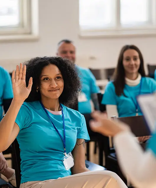 A medical professional raises her hand to ask a question. 