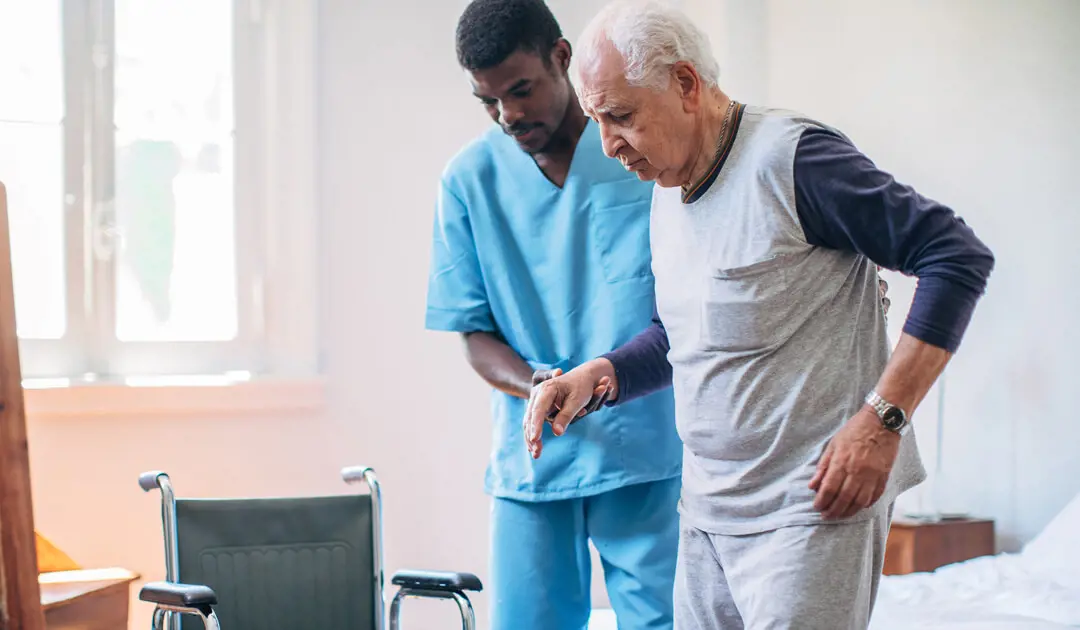 Male nurse helping an elderly male dementia care patient walking