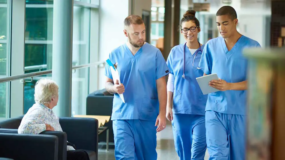 Three medical staff walking down a hallway