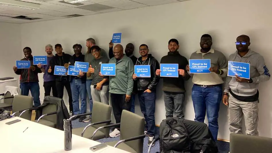 Participants of a CPI Training day holding up completion signs