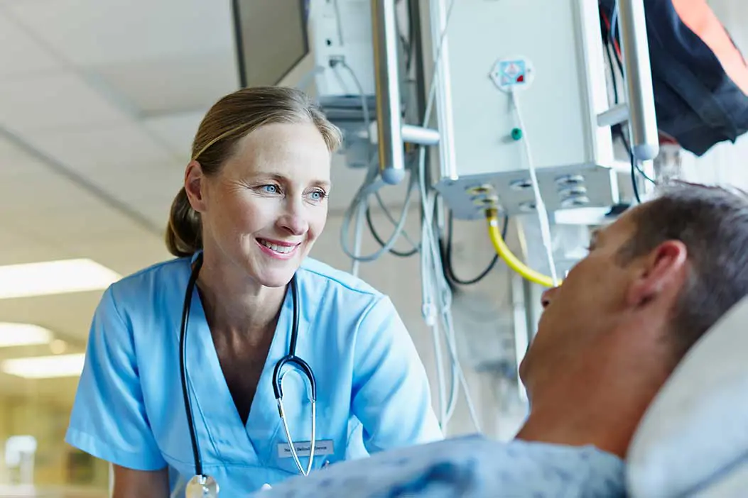 A medical professional at a patient's bedside.