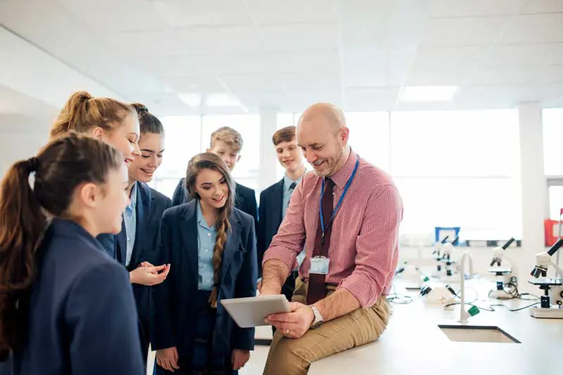 Teacher showing his students something on a tablet