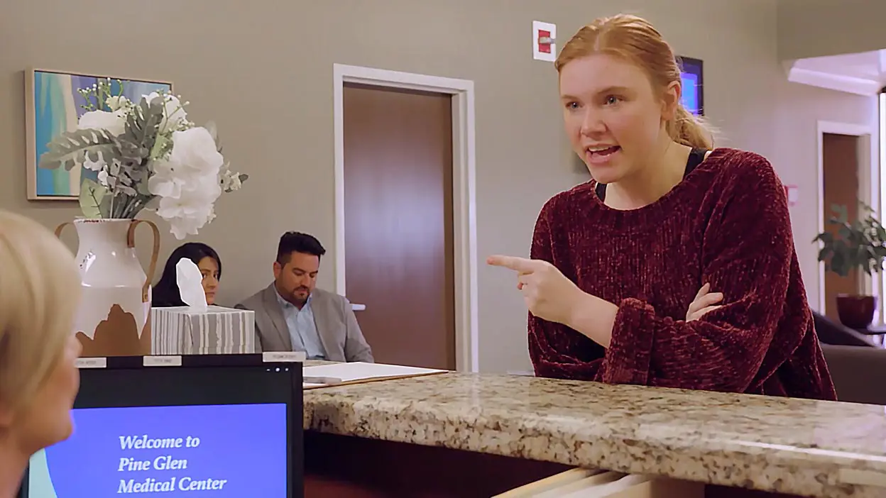 An angry woman at a reception desk.