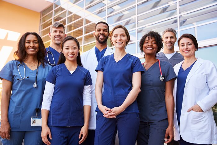 Doctors and nurses standing in front of a hosptial