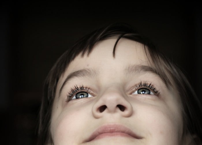 Smiling child with blue eyes looking up