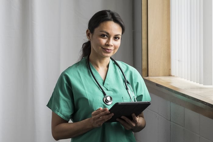 Confident nurse standing with a tablet